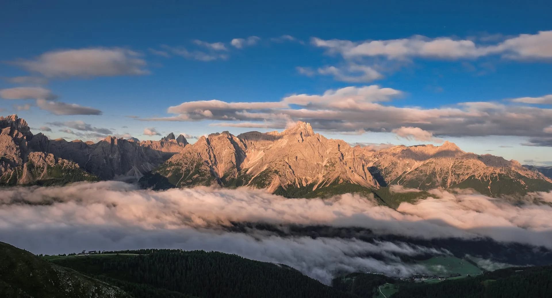 Alpine mountain range above clouds at sunrise, view from Sillianer Hut.