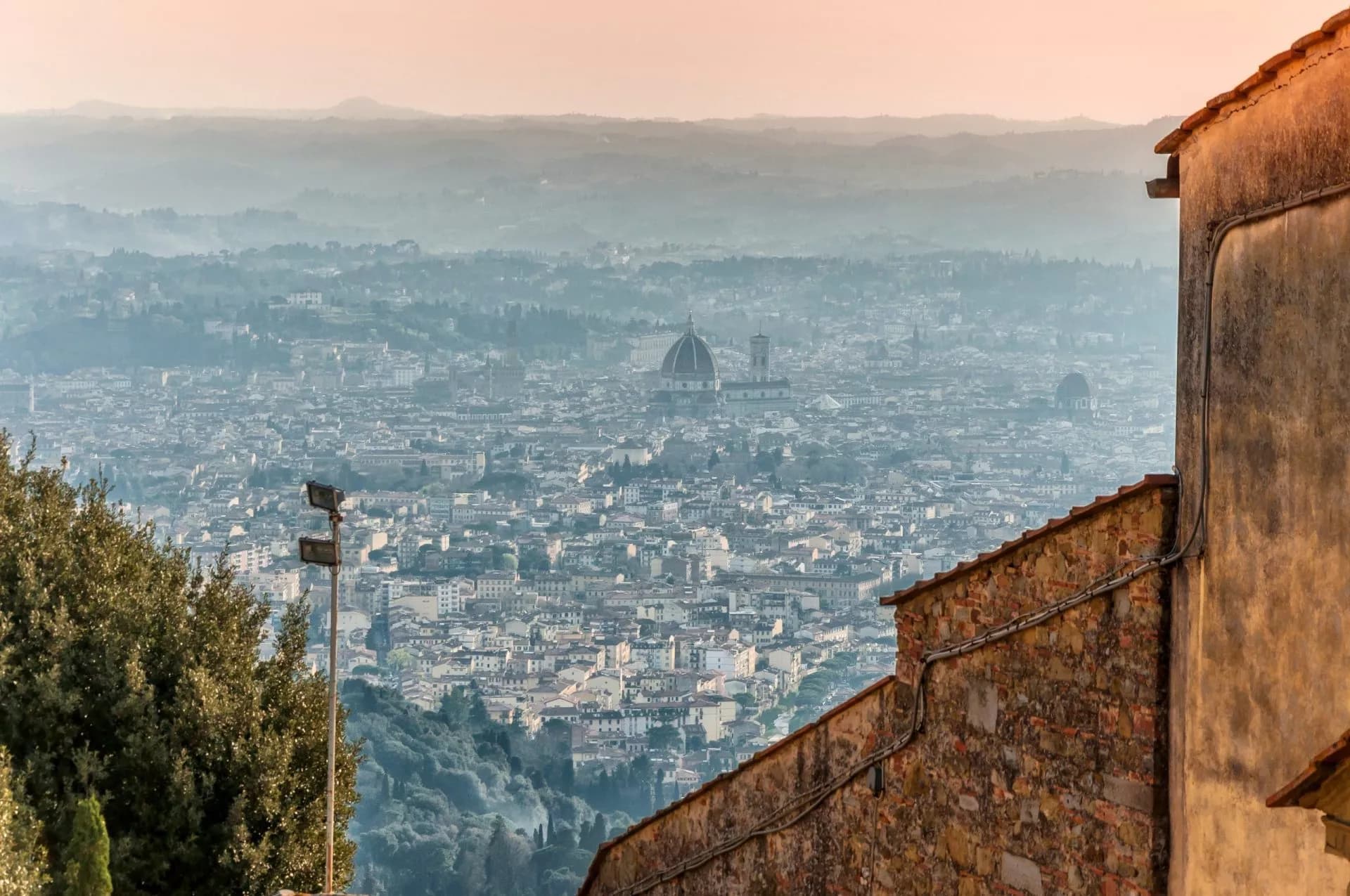 View of Florence cityscape with Duomo dome from Fiesole hills at sunrise.