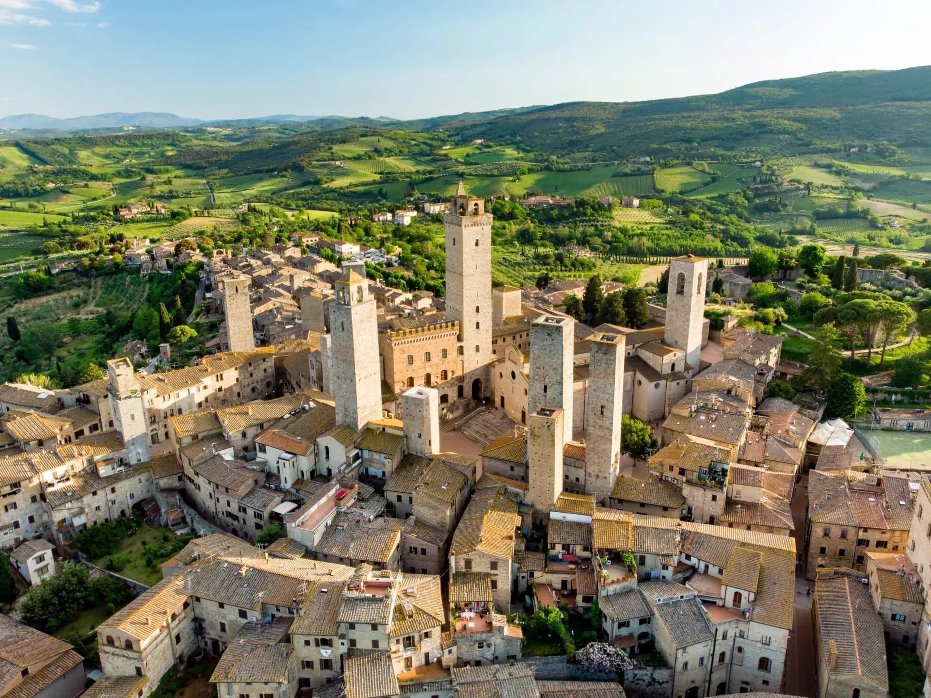 San Gimignano medieval towers overlooking terracotta roofs and green Tuscan hillsides