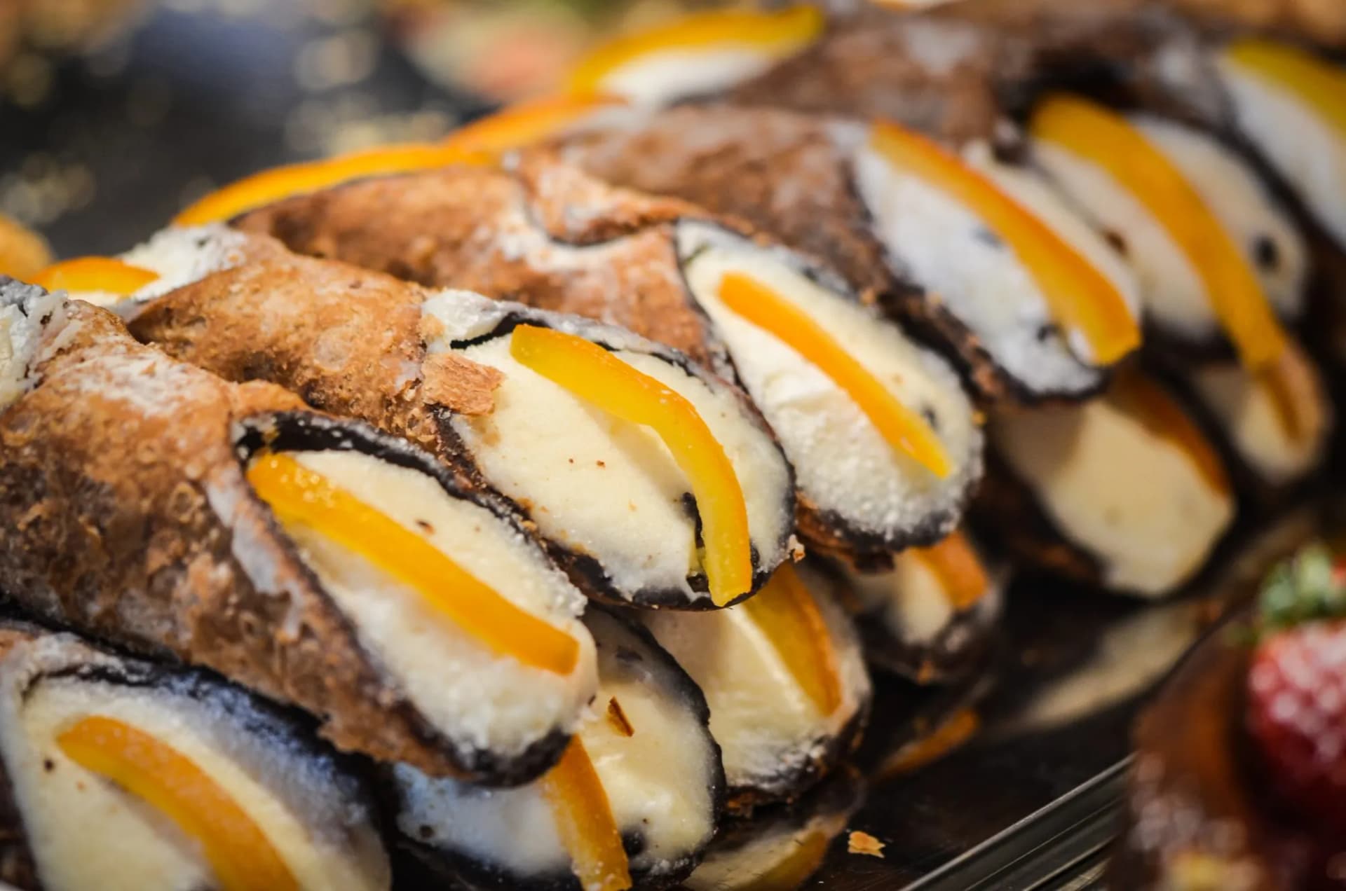 Fresh Sicilian cannoli filled with ricotta and candied orange peel on display
