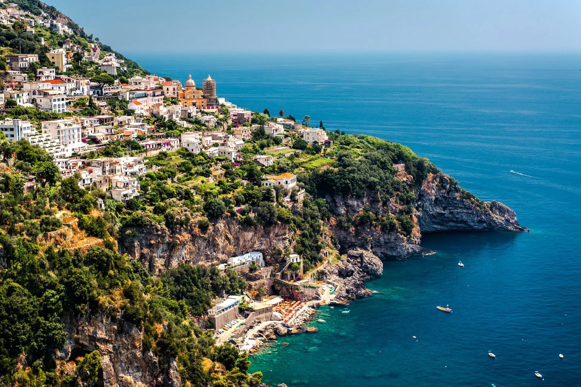 View of Praiano town built on steep cliffs overlooking the deep blue Mediterranean Sea.