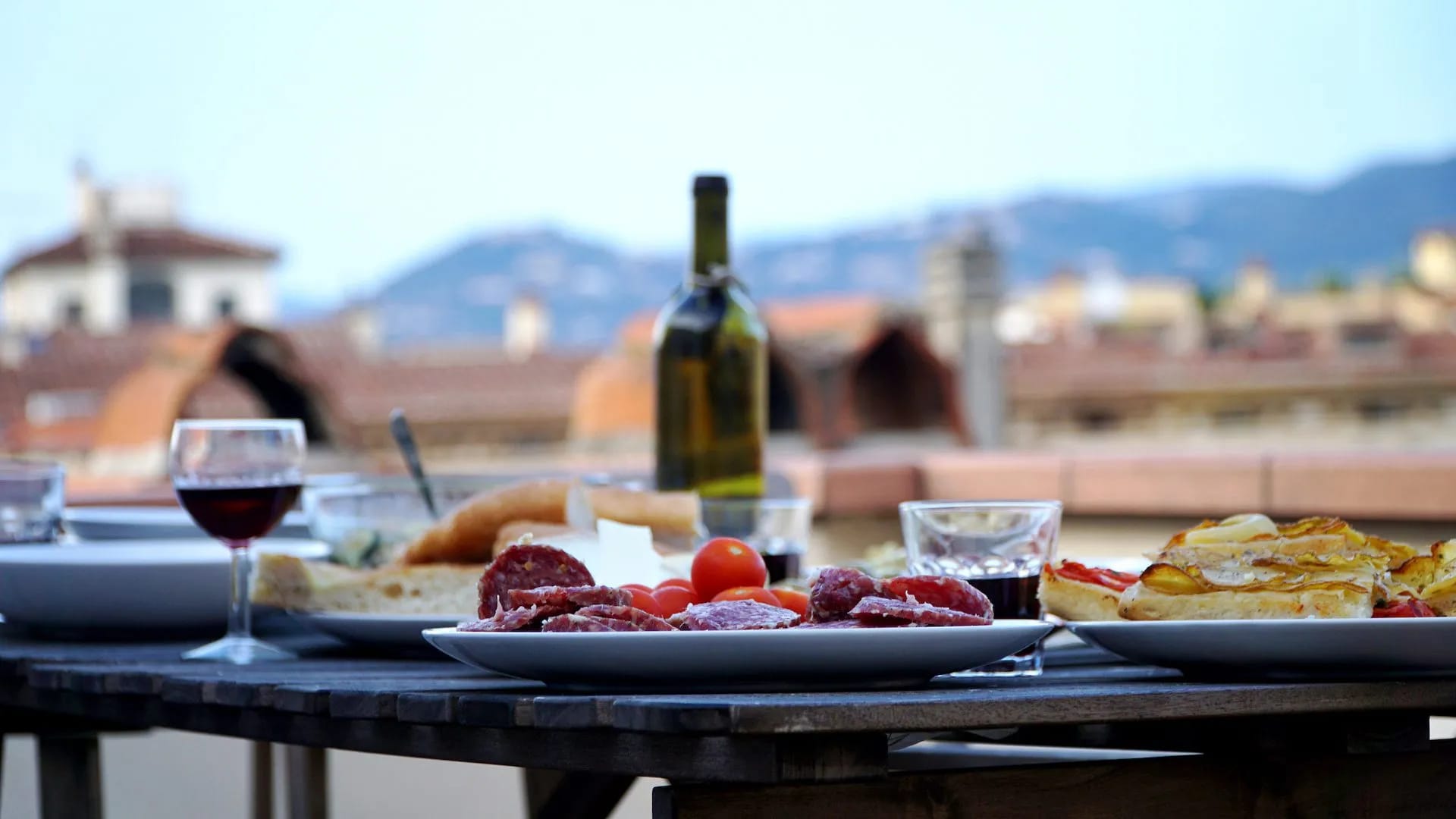 Rooftop dining with charcuterie, wine, and Tuscan city view in Florence