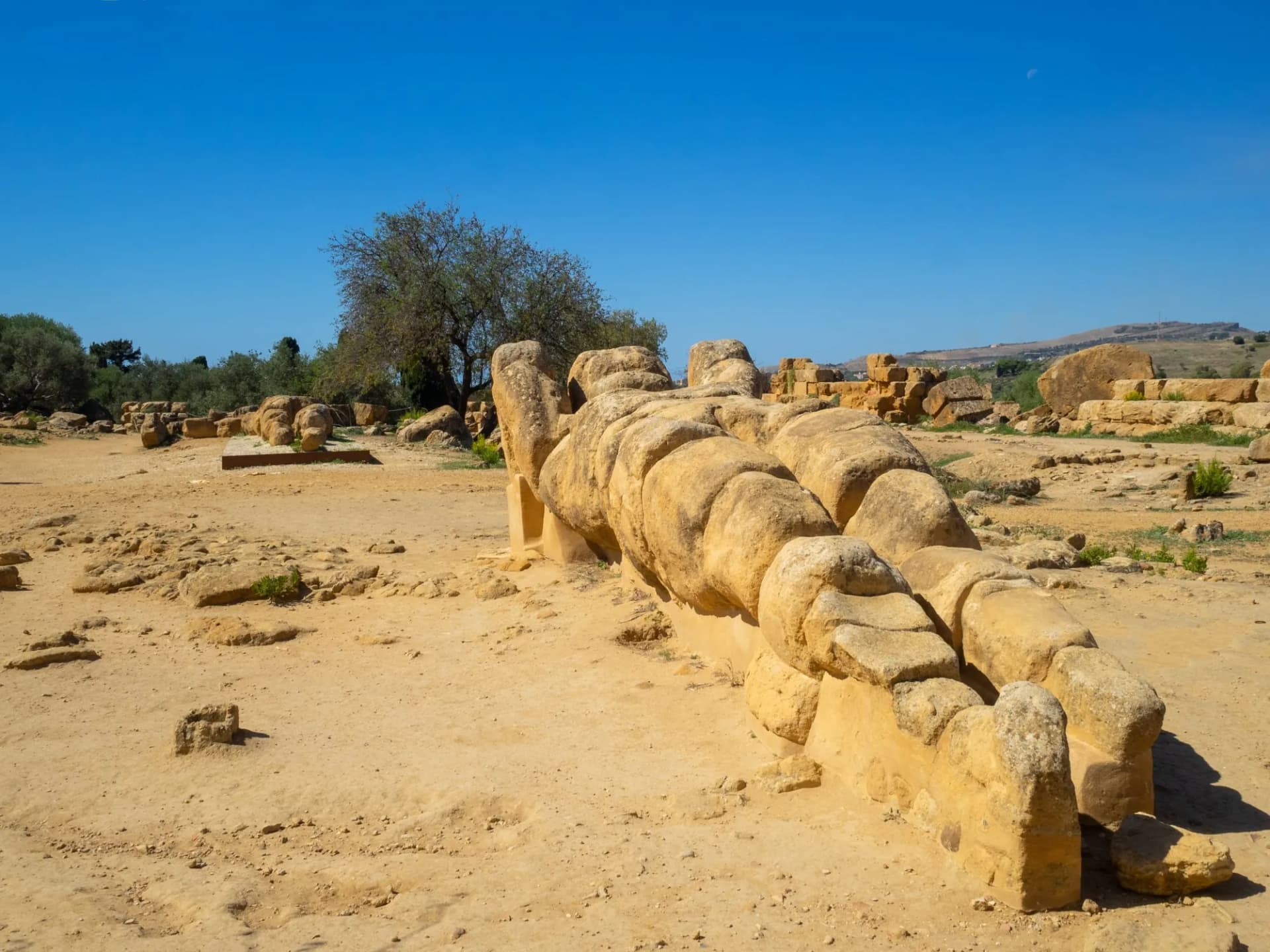 An atlas remains from the Temple of the Olympian Zeus stand on the ground in Valle dei Templi