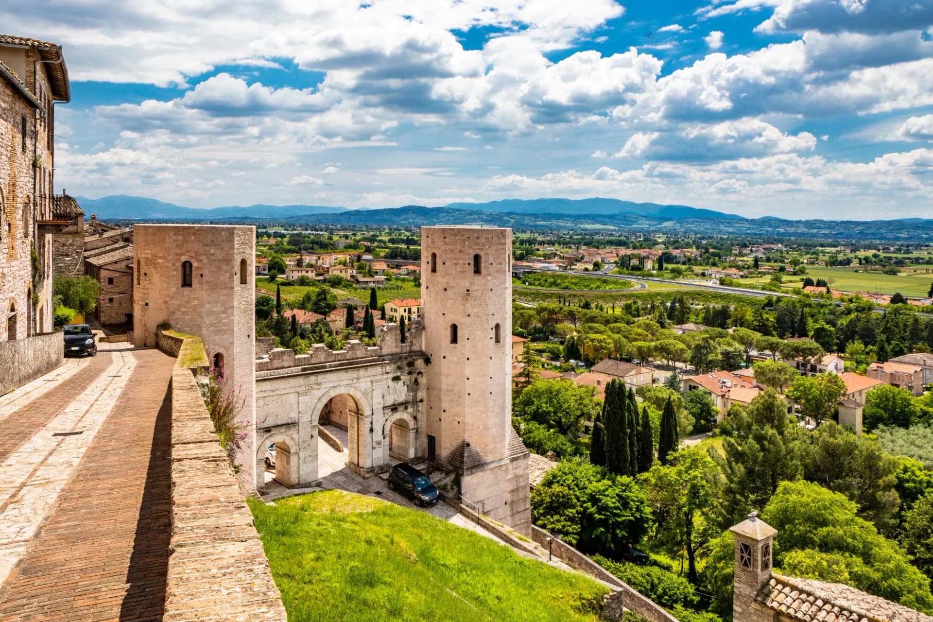 The Porta di Venere, from the Roman era, made of white travertine, with its three arches and the two towers of Properzio. In Spello, province of Perugia, Umbria, Italy.
