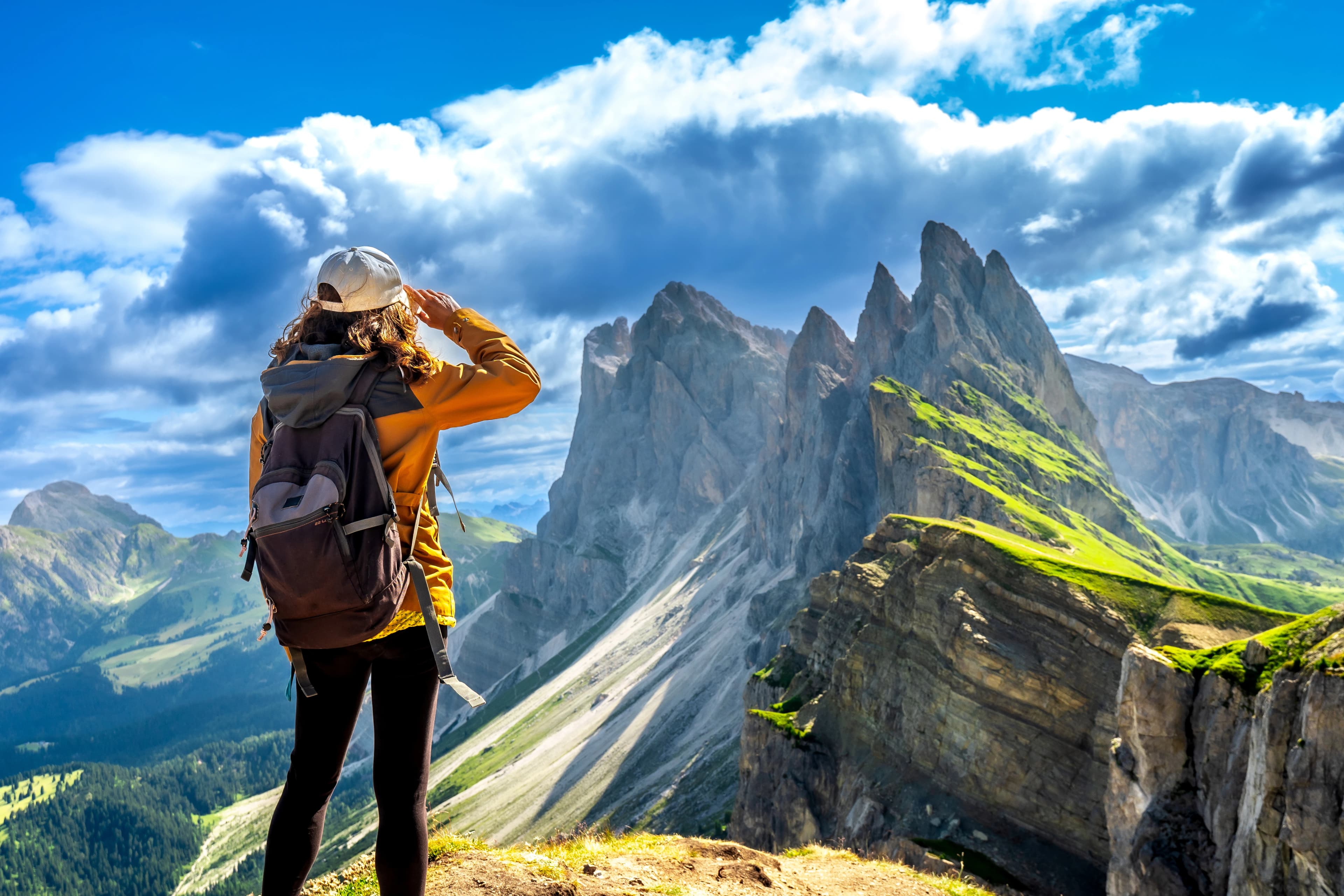 Female hiker admiring the majestic seceda peaks in the italian dolomites