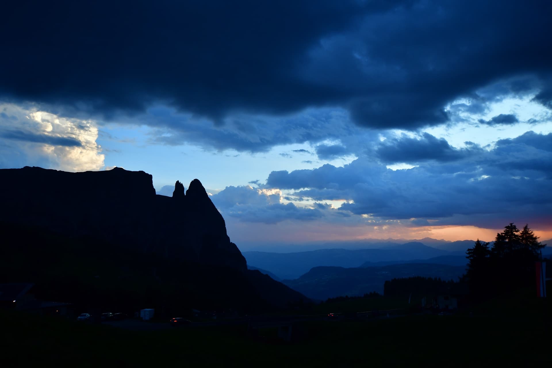 Dolomites mountain pinnacles silhouetted against a dramatic dusk sky with dark clouds